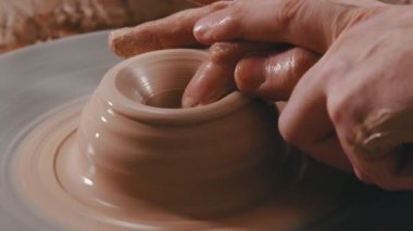 Kil içinde derinleşen elleri şekillendiren insanlar.