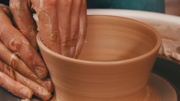 曼斯的手在陶瓷轮上从粘土中雕琢一个罐子 — 图库视频影像