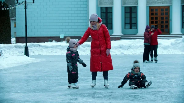 子供と一緒に氷の上でスケート若い女性 — ストック写真