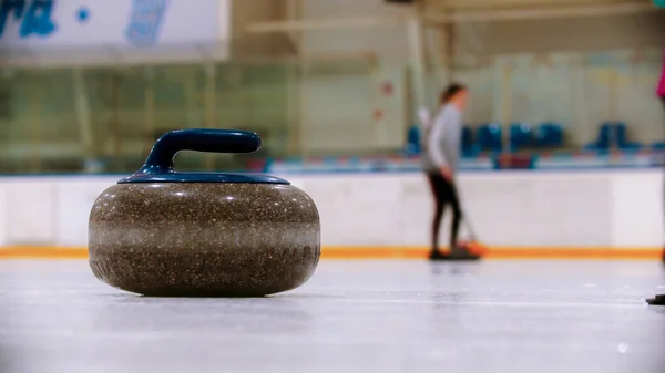 Curling - uma pedra de granito com cabo azul no campo de gelo — Fotografia de Stock