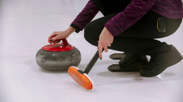 Curling formazione - donna in possesso di una pietra di granito con manico rosso e tenendo una spazzola speciale — Foto Stock