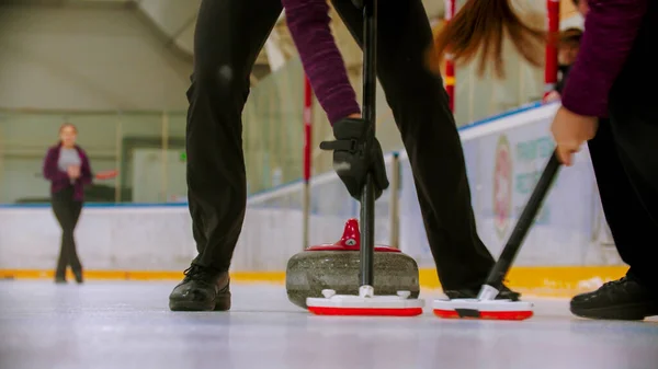 Curling - prowadzący granitowy kamień na lodzie - oczyszczający lód przed kamieniem — Zdjęcie stockowe