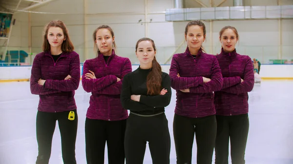 Curling formación - el juez de pie en la pista de hielo con sus estudiantes mujeres - sus manos cruzadas en el pecho —  Fotos de Stock
