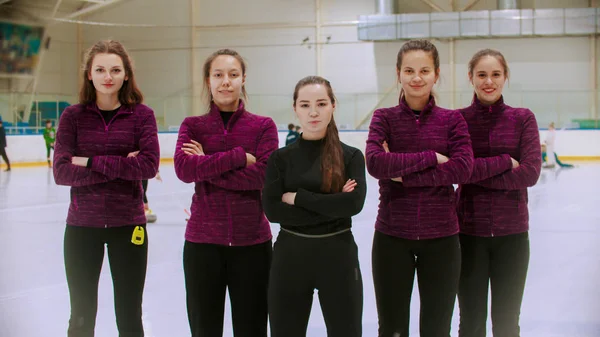 Curling treinamento dentro de casa - o juiz em pé na pista de gelo com suas estudantes mulheres - suas mãos cruzadas no peito — Fotografia de Stock