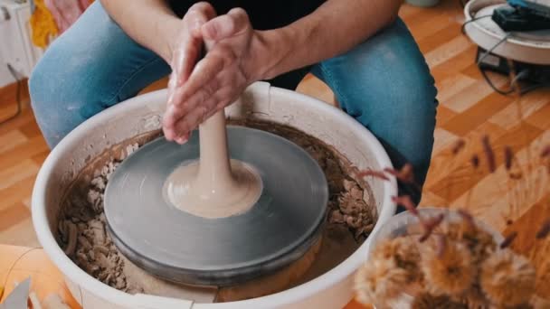 Een man pottenbakker vormt een langere vorm uit natte klei — Stockvideo
