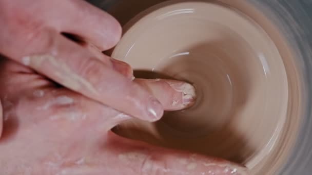 Чоловік гончар, що скульптурить поглиблення в глиняній фігурі пальцями — стокове відео