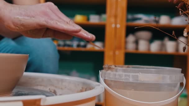 Man krukmakare skulptera figur av lera hjälpämne med hjälp av scapula - tar bort överskott — Stockvideo