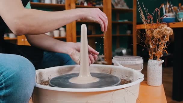 Een stuk klei in langere vorm draaiend op een pottenbakkerswiel — Stockvideo