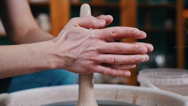 Pottery craftsmanship - a mans hands forming piece of clay in longer shape spinning on a potters wheel — 비디오