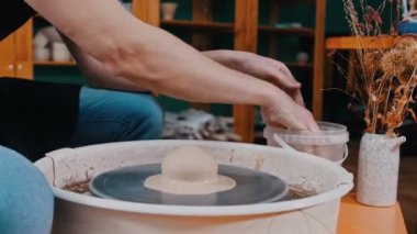 Bir adam elleri kilden bir parça yapıyor - tencere yapıyor
