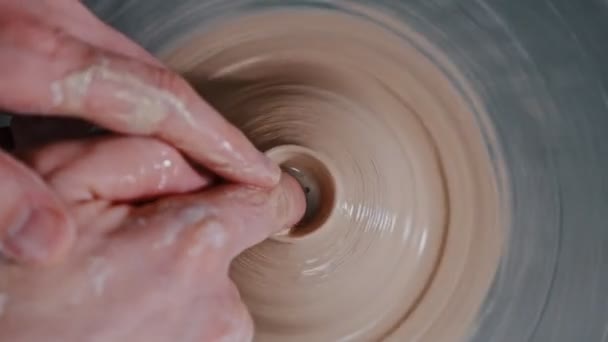 Homem oleiro esculpir o aprofundamento em figura de barro usando o dedo - fazendo um pote — Vídeo de Stock