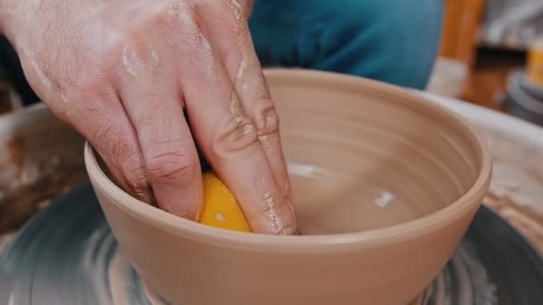 Man potter working with a clay figure using a sponge — 비디오