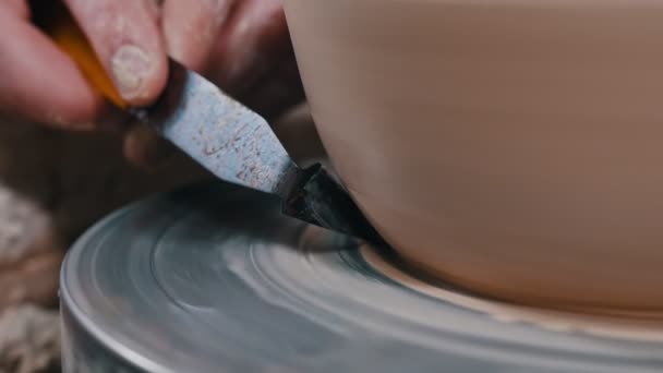 Ceramista uomo che lavora con una pentola con un coltello stucco fare un bordo affilato — Video Stock