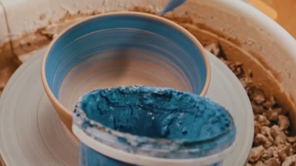 Schilderen van een gebakken pot in blauwe kleur met behulp van een borstel — Stockvideo