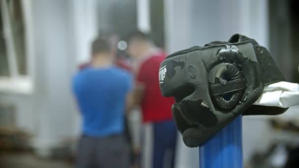 Un gimnasio para el entrenamiento de boxeo - casco protector maltratado en primer plano — Vídeo de stock