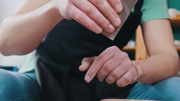 Άνθρωπος αγγειοπλάστη γλυπτική κατσαρόλα από πηλό βοηθητικό χρησιμοποιώντας ωμοπλάτη - στίλβωση των πλευρών — Αρχείο Βίντεο