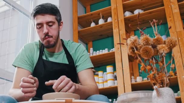 Man potter working with a clay pot in the workshop — Stock Video