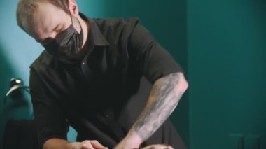Erkek berber müşterisinin saçını yıkıyor.