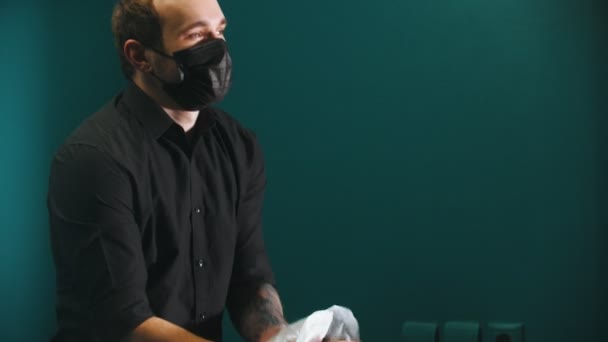Парикмахер с татуировками, высушивающий волосы клиента — стоковое видео