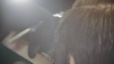 Berber müşterileri makasla ıslak saçlarıyla kesiyor.