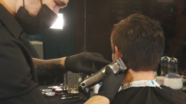 Перукар вирізає волосся на клієнті з підстрижкою. — стокове відео