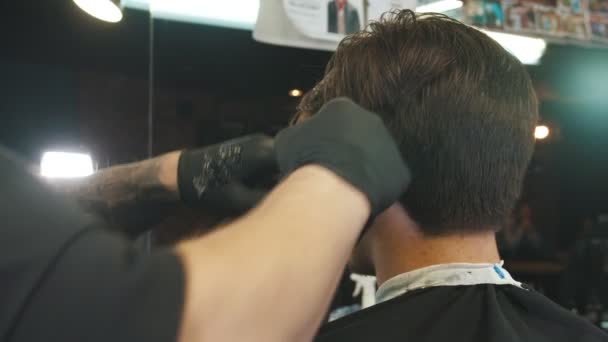 Um barbeiro aplicando o creme de barbear nas bordas do cabelo para os toques finais usando as lâminas — Vídeo de Stock