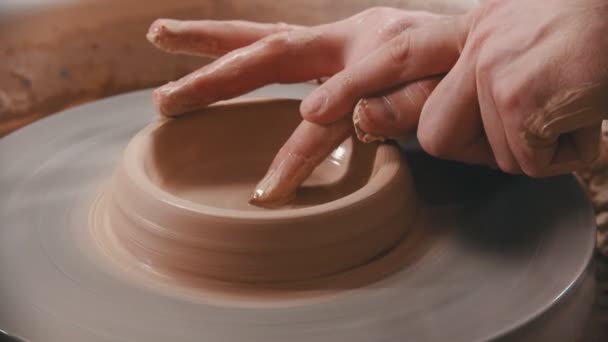 Pottery - the master is unfolding clay with his finger on the potters wheel — Stock Video