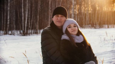 A married couple hugging outdoors at winter