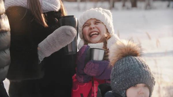Laughing little girl drinking hot drink outdoors — Stockfoto