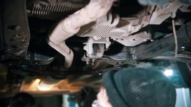 Arabanın altında yürüyen bir işçi.