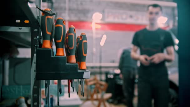 Set van schroevendraaiers in verschillende maten geplaatst in de auto reparatieservice - de mens neemt een van hen — Stockvideo
