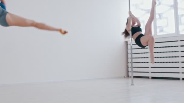 Young women on pole dancing lesson in the bright studio — Stock Video