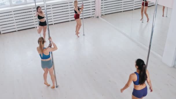 Mujeres jóvenes bailando usando un poste en el estudio — Vídeo de stock