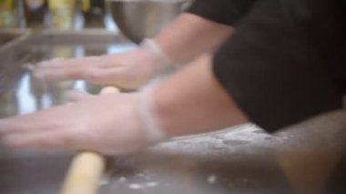 Restaurant kitchen - making a dough - flatten the dough with a rolling pin indoors