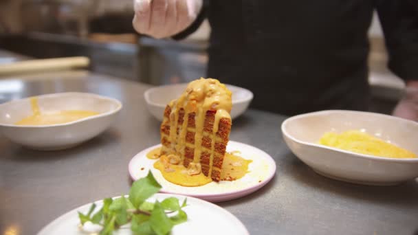 Chef pouring sweet sauce and granola on the piece of cake — 비디오