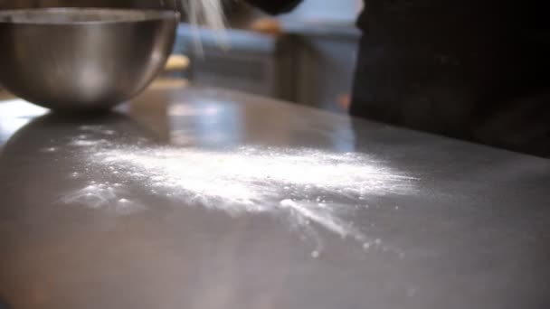 Шеф-повар бросает муку на стол, прежде чем делать тесто — стоковое видео