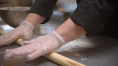 Chef rolling on piece of dough to make it flat