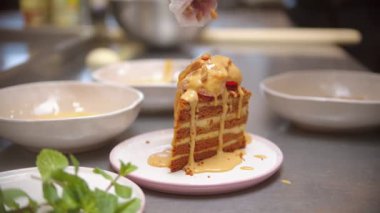 Chef sprinkles a piece of cake with nuts