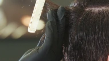 Barber brushing clients wet hair for cutting