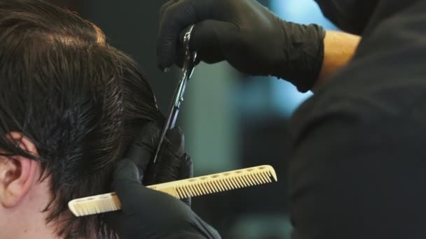 Barber cutting clients wet hair on the back of the head with a scissors — ストック動画