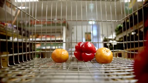 Carrello della spesa - scegliere gli oggetti nel negozio di alimentari - mettere verdure e frutta nel carrello — Video Stock