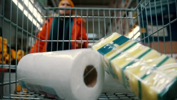 Grocery basket - a man is putting household goods in a cart — Αρχείο Βίντεο