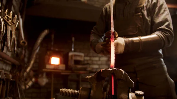 Muž kovář, který kroutí kouskem kovu — Stock fotografie