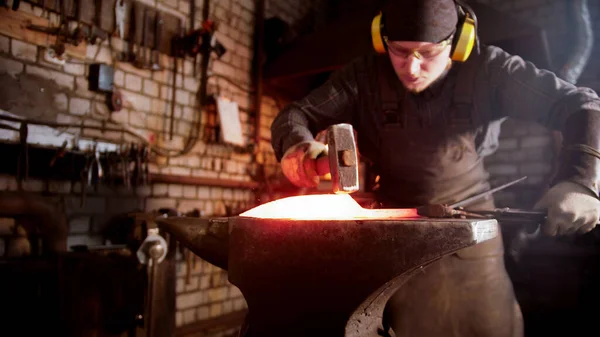 Schmied schmiedet in seiner Werkstatt mit einem Hammer eine Messerklinge — Stockfoto