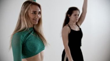 Two sportive women warming up at fitness training - moving their hands