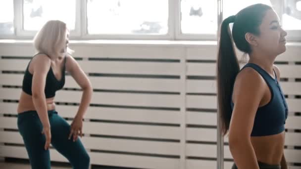 Жінки в спортивному одязі зігріваються в студії — стокове відео