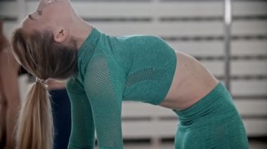 Slim woman doing yoga in bright studio