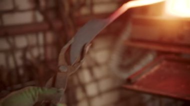 A man blacksmith heating up handle of the knife and start forming it on the anvil