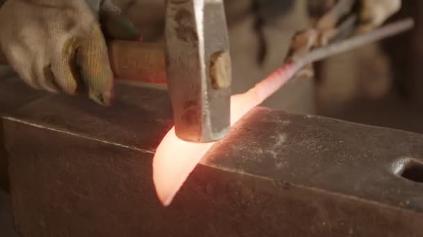 A man blacksmith hitting a hot knife sample with a hammer — 图库视频影像