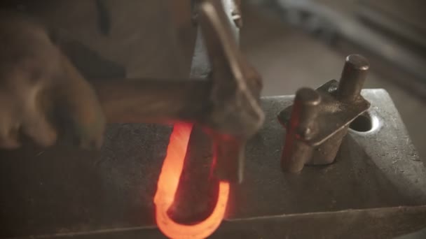 Herrero golpeando el metal caliente en un mango de cuchillo — Vídeos de Stock